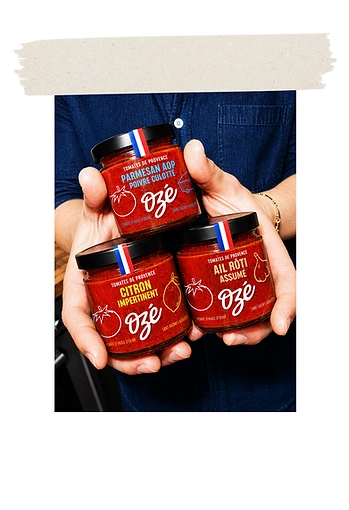 Trois pots de sauce Ozé tenus à deux mains